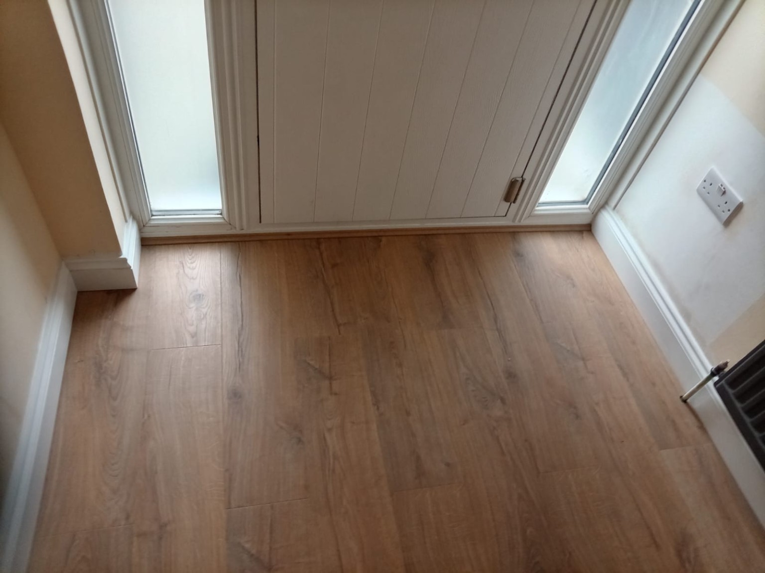 Timber-effect entrance flooring beside a fitted front door